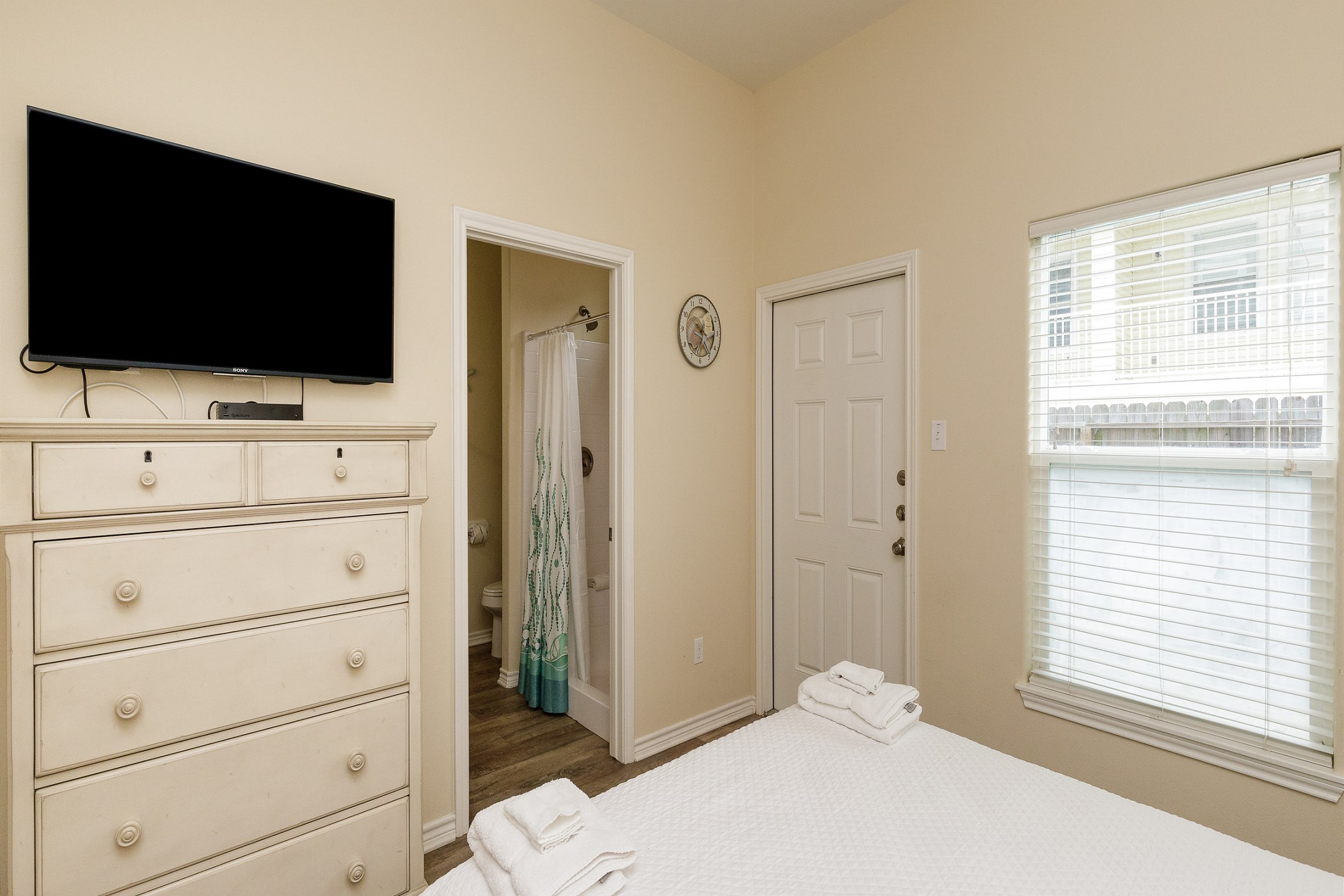 Master bedroom on the first floor with queen size bed, private bathroom, access to the patio, and flat screen TV