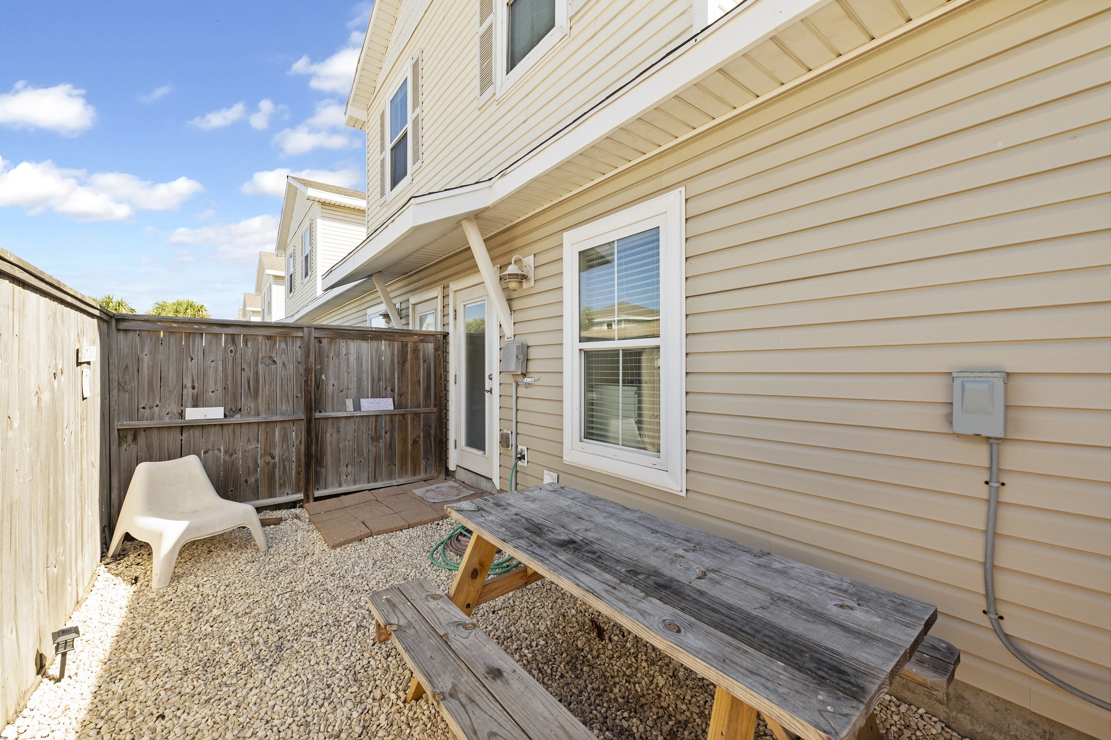 Private, fenced in back patio with picnic table to relax on your vacation