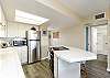 Fully equipped kitchen with stainless steel appliances and breakfast bar seating 