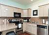 Fully equipped kitchen with stainless steel appliances and ample storage space 