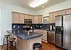 Fully equipped kitchen with stainless steel appliances and breakfast bar with seating for two