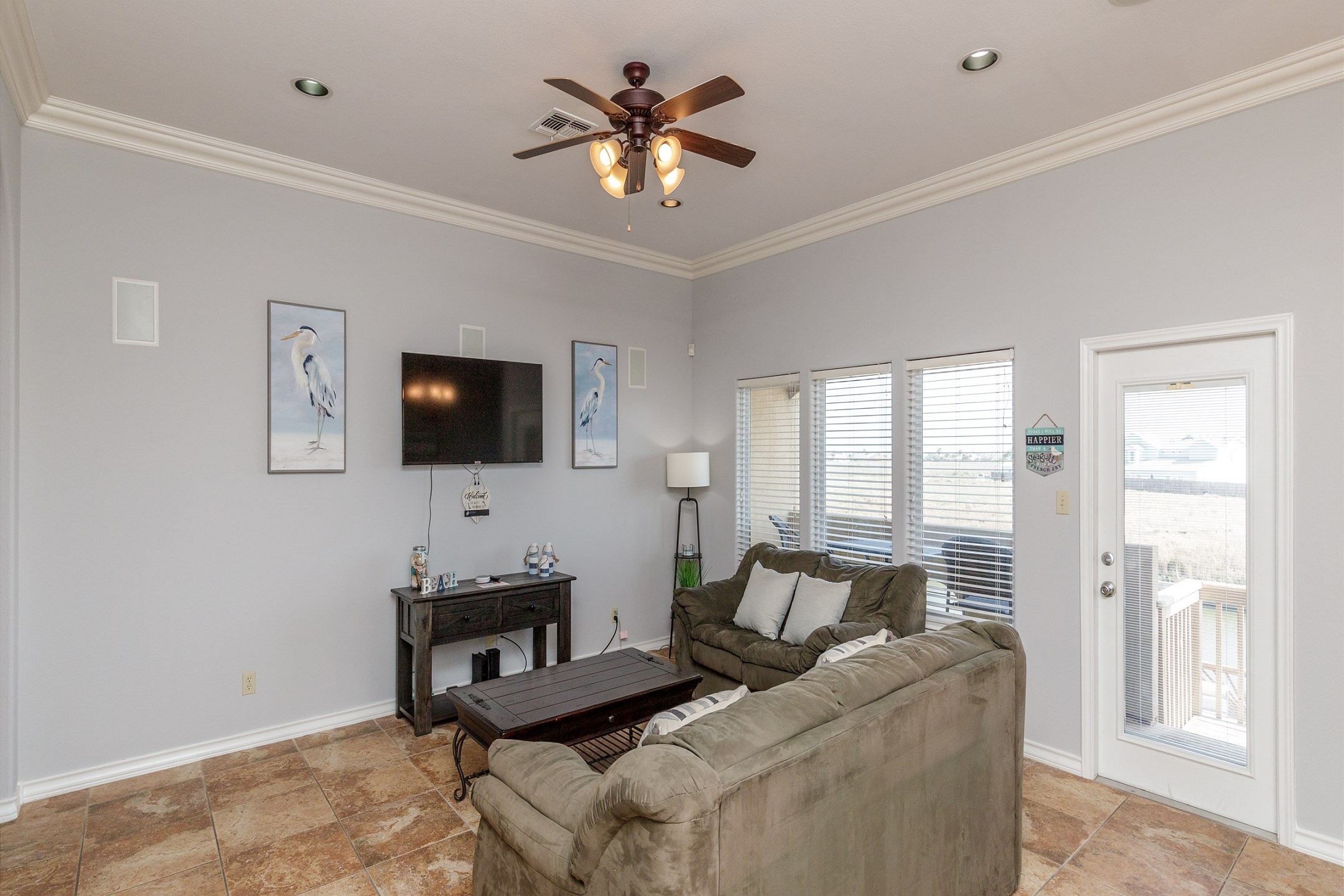 Relaxing living space with flat screen TV, natural light shinning in and access to the sundeck