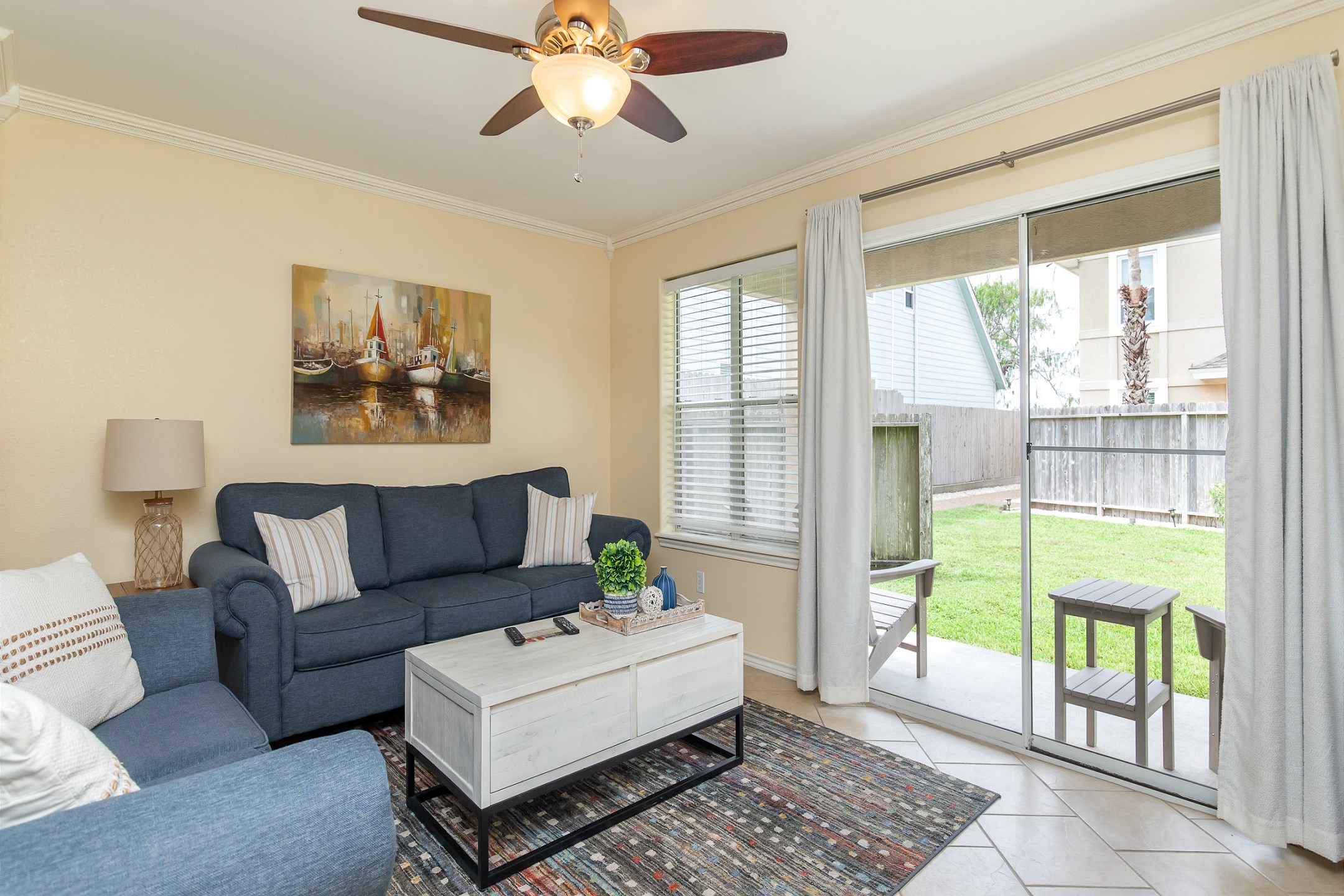 Open concept living area with modern furnishings and bright light shinning in from the patio space