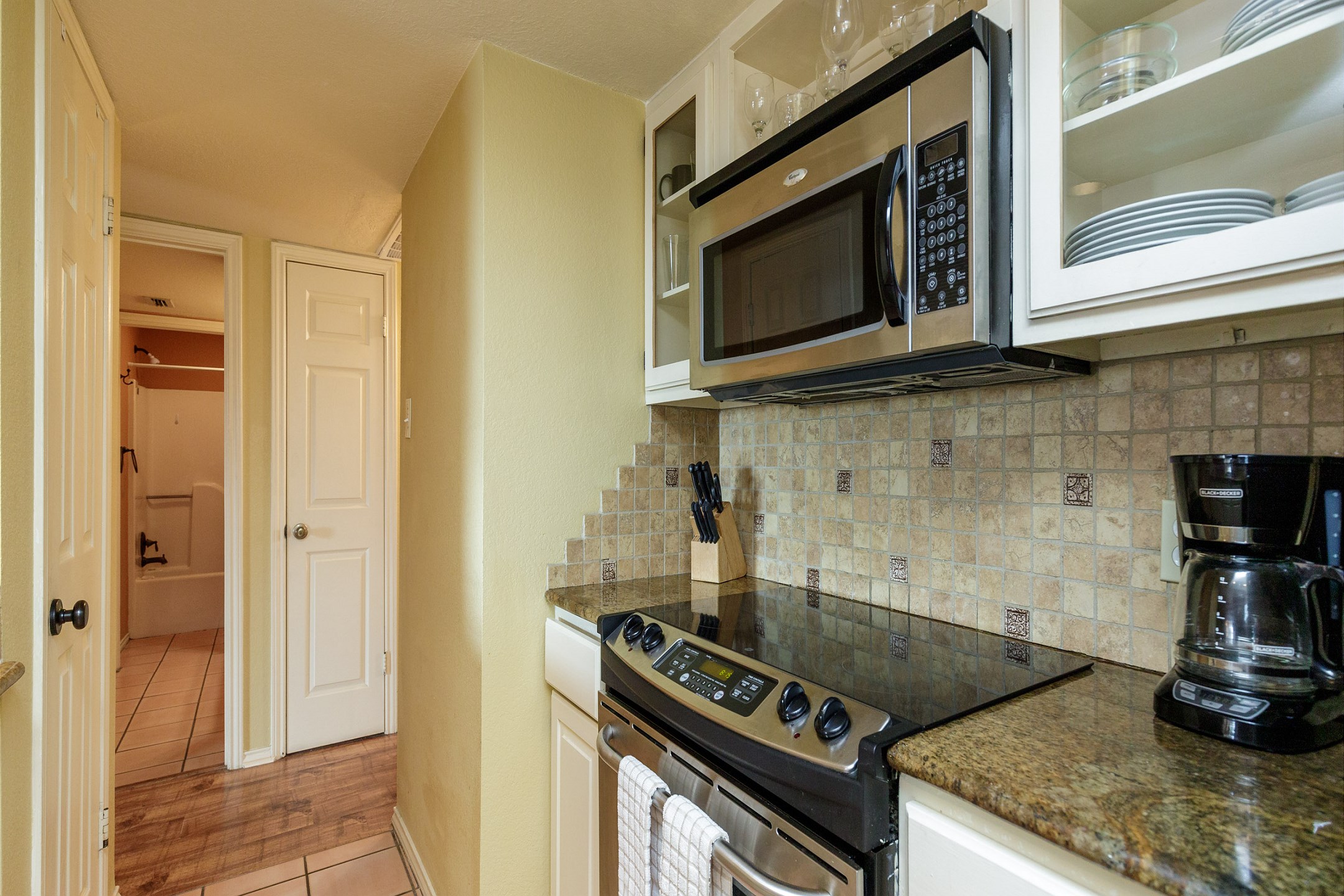 Beautiful kitchen area with ample storage, coffee maker, toaster, cookware, dinnerware, and other kitchen essentials provided