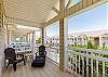 Private balcony off the master suite with chairs and a view of the pool 