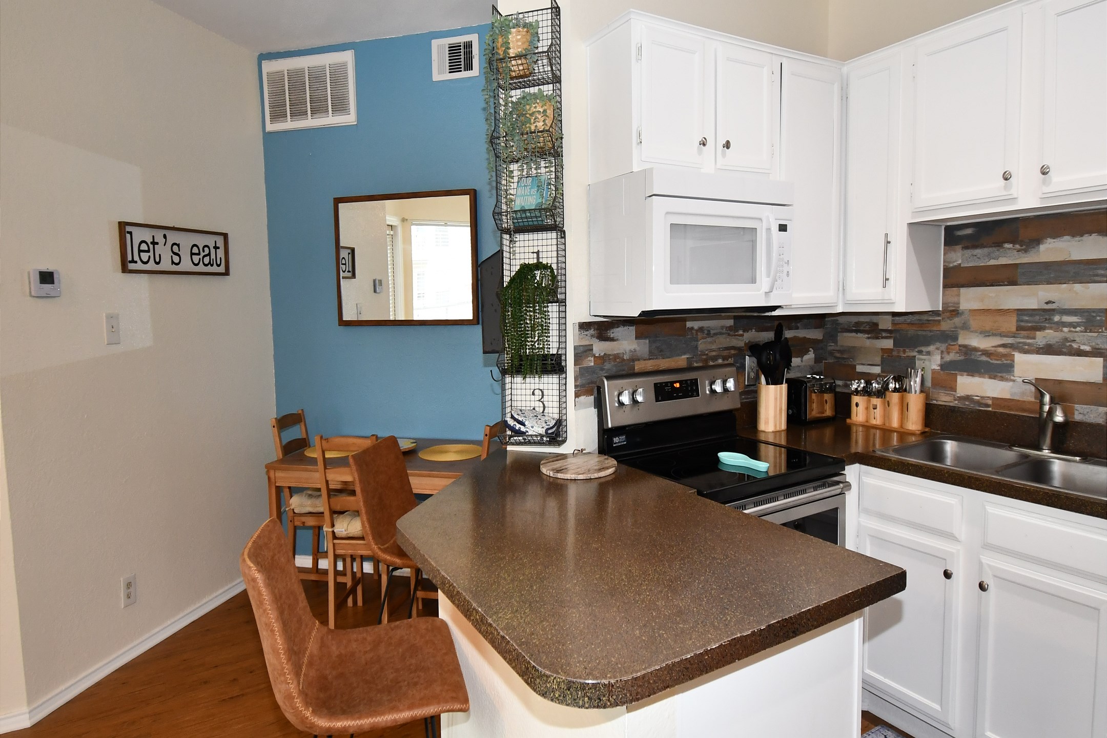 Breakfast bar, dining table, and well-equipped kitchen