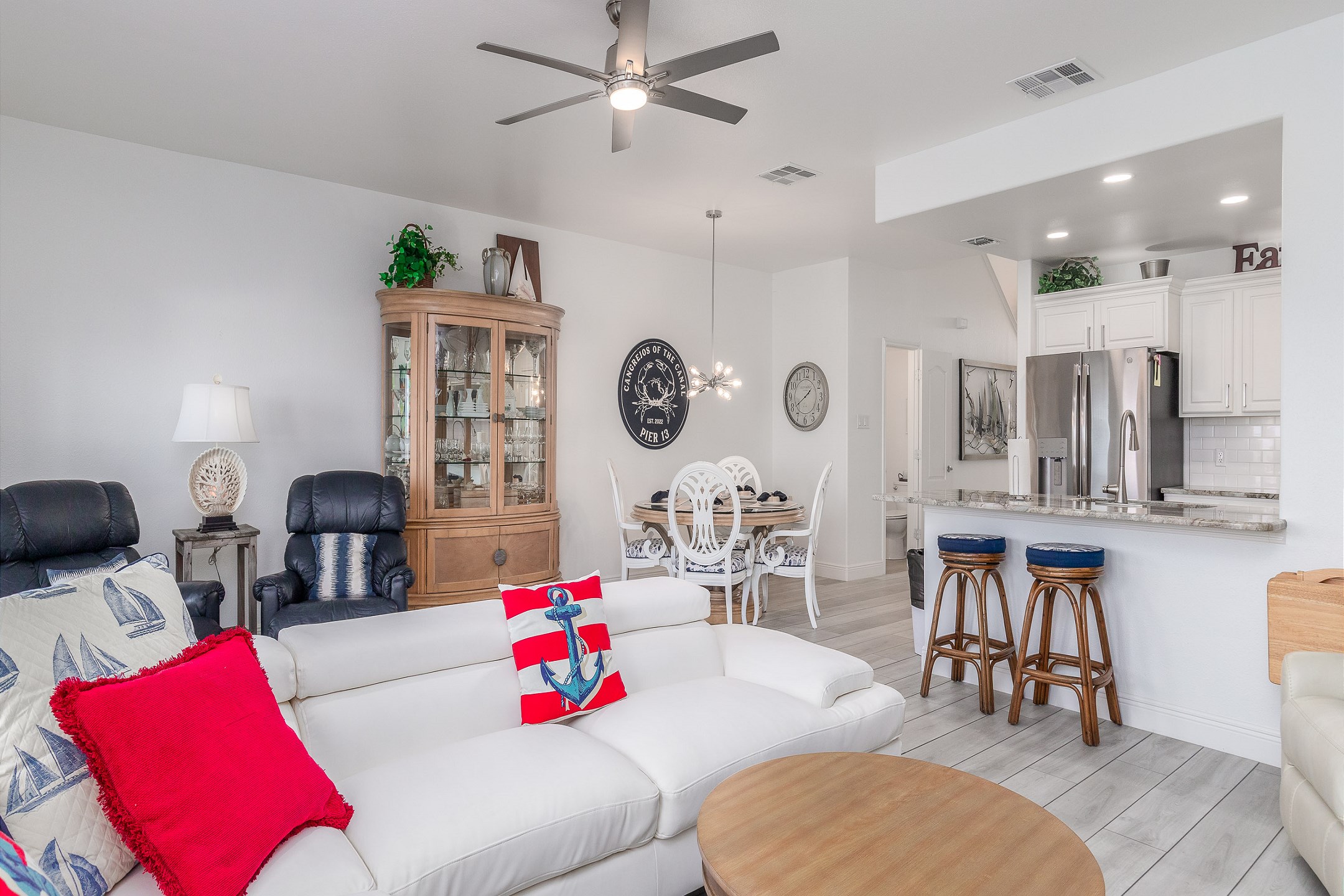 Open concept living, dining and kitchen area to spend time with the family that offers bright lighting and coastal features 