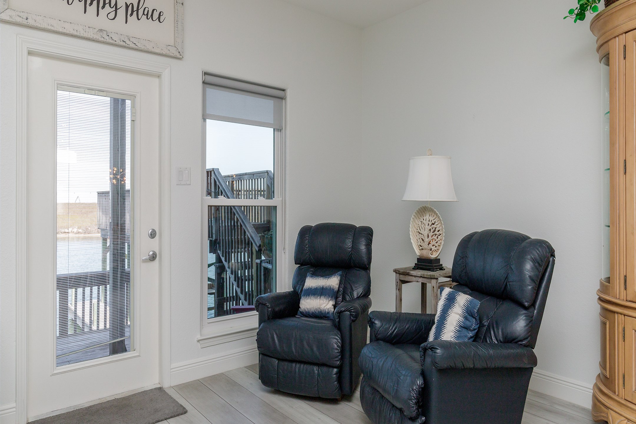 Lovely seating area for two with comfy recliners that looks out onto the deck and canal