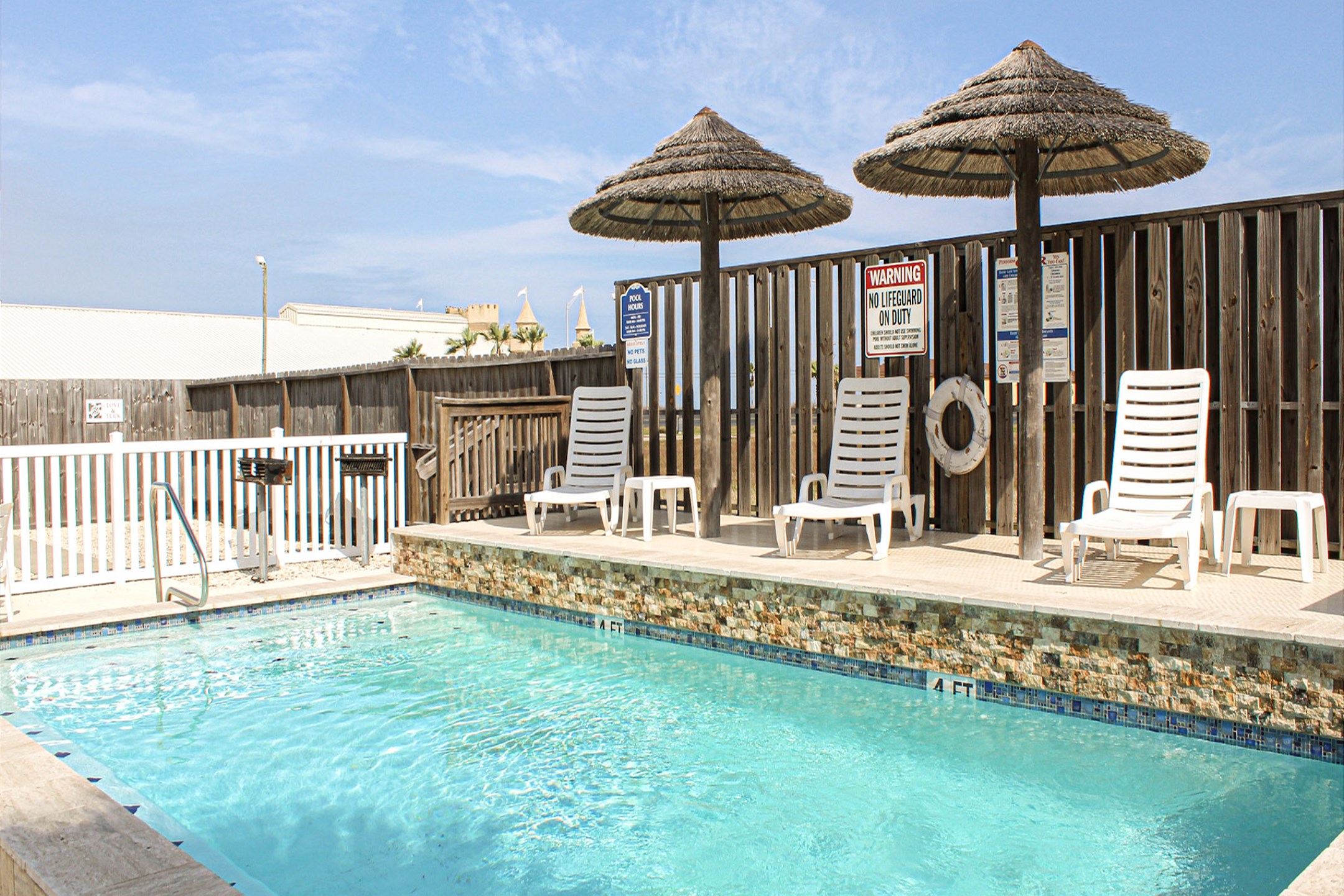 Lovely pool area with lounge chairs and grills