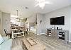Open concept living, dining and kitchen space with bright light shinning in
