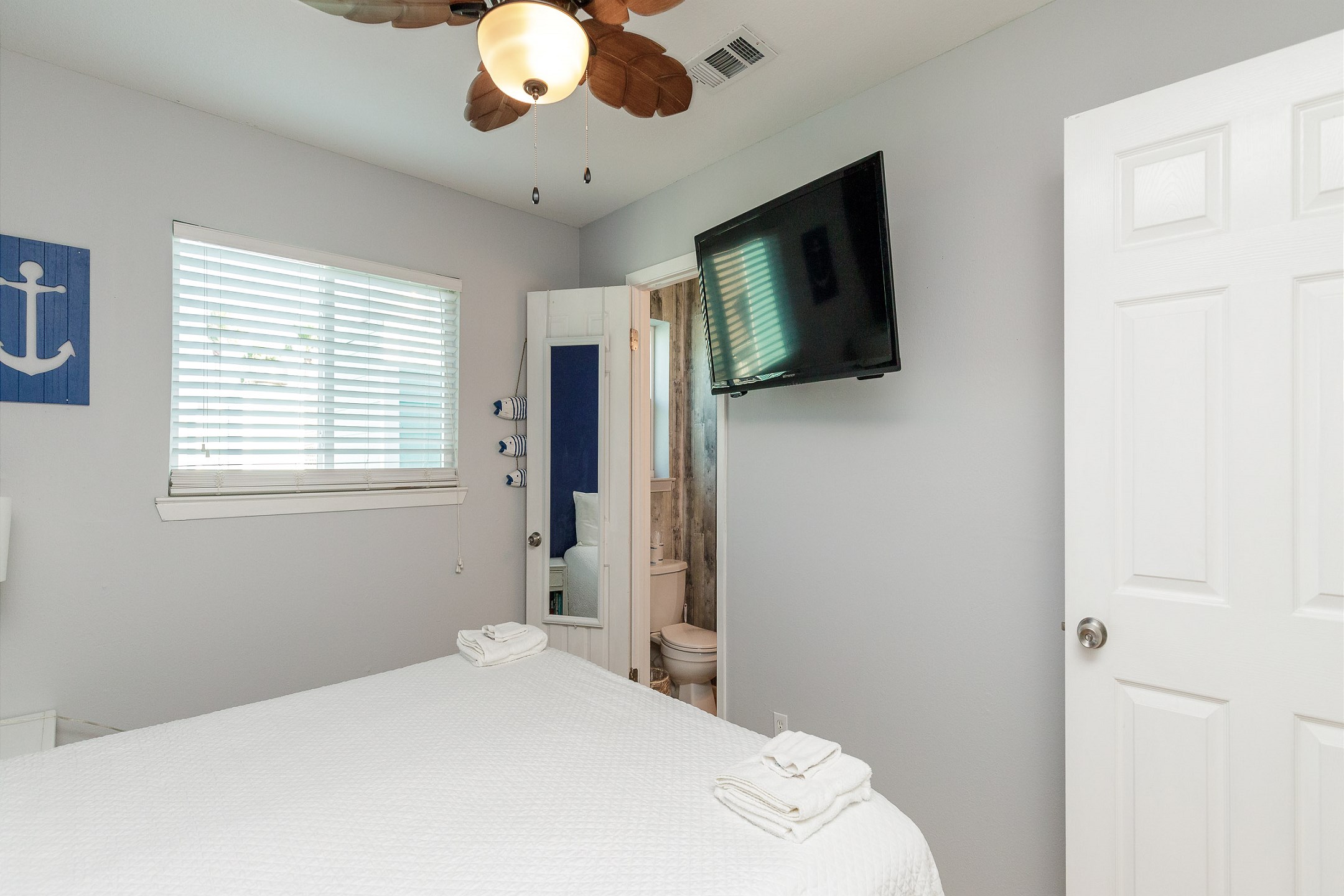 Master bedroom on the second floor with king size bed, flat screen TV, and half bathroom