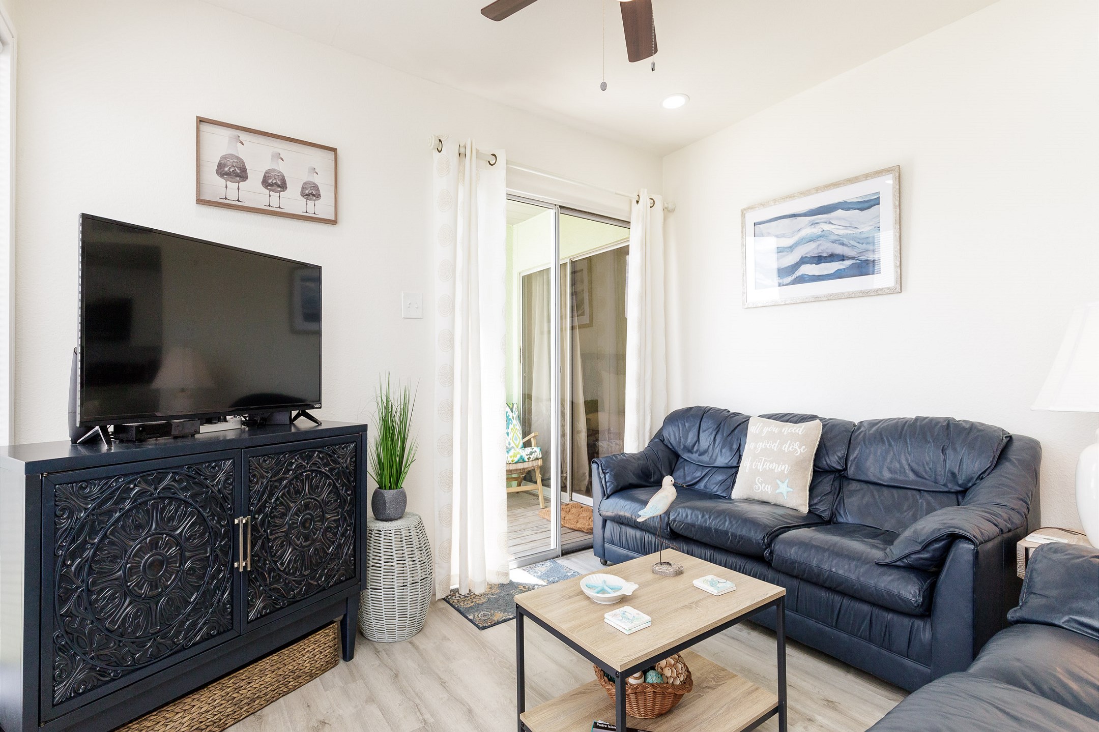 Living area with flat screen TV to enjoy and comfy furniture to relax on with easy access to the private patio space