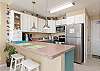 Fully equipped kitchen with stainless steel appliances and breakfast bar with seating for two 