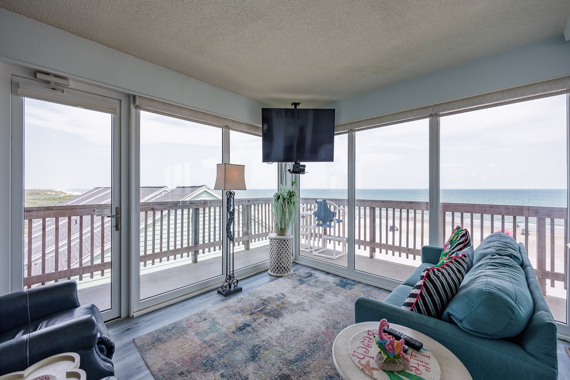 Living space with bright light shining in, amazing water views and flat screen TV