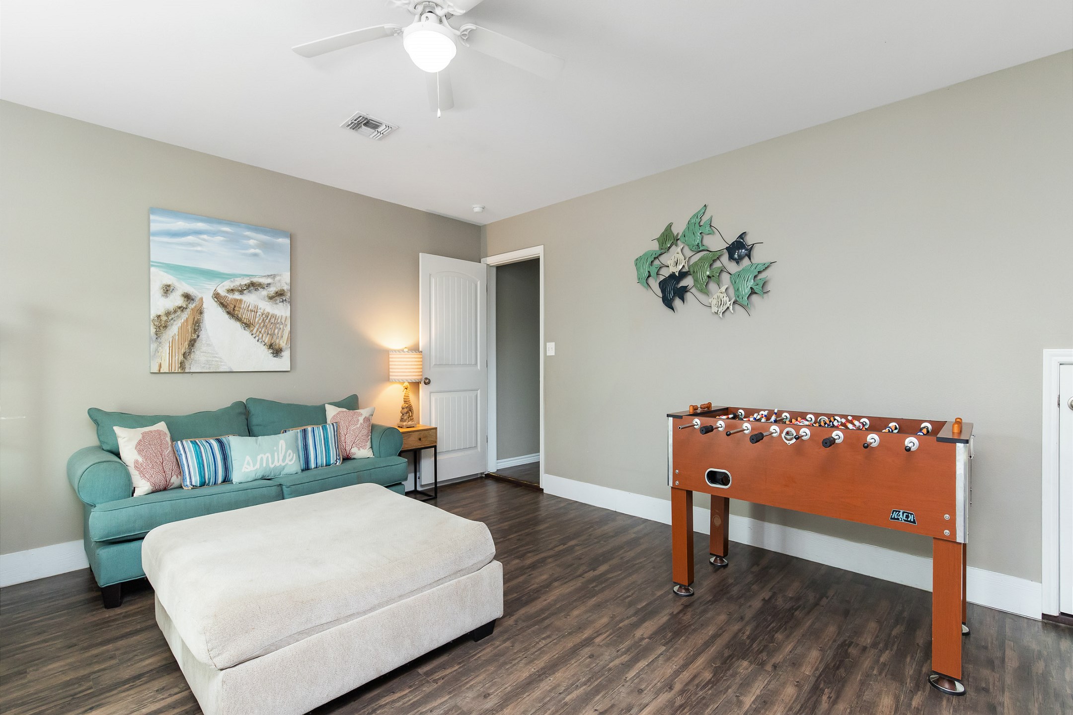 Multifunctional family room featuring two sets of twin bunk beds, a sleeper sofa, a television for entertainment, and a foosball table, making it ideal for both relaxation and play
