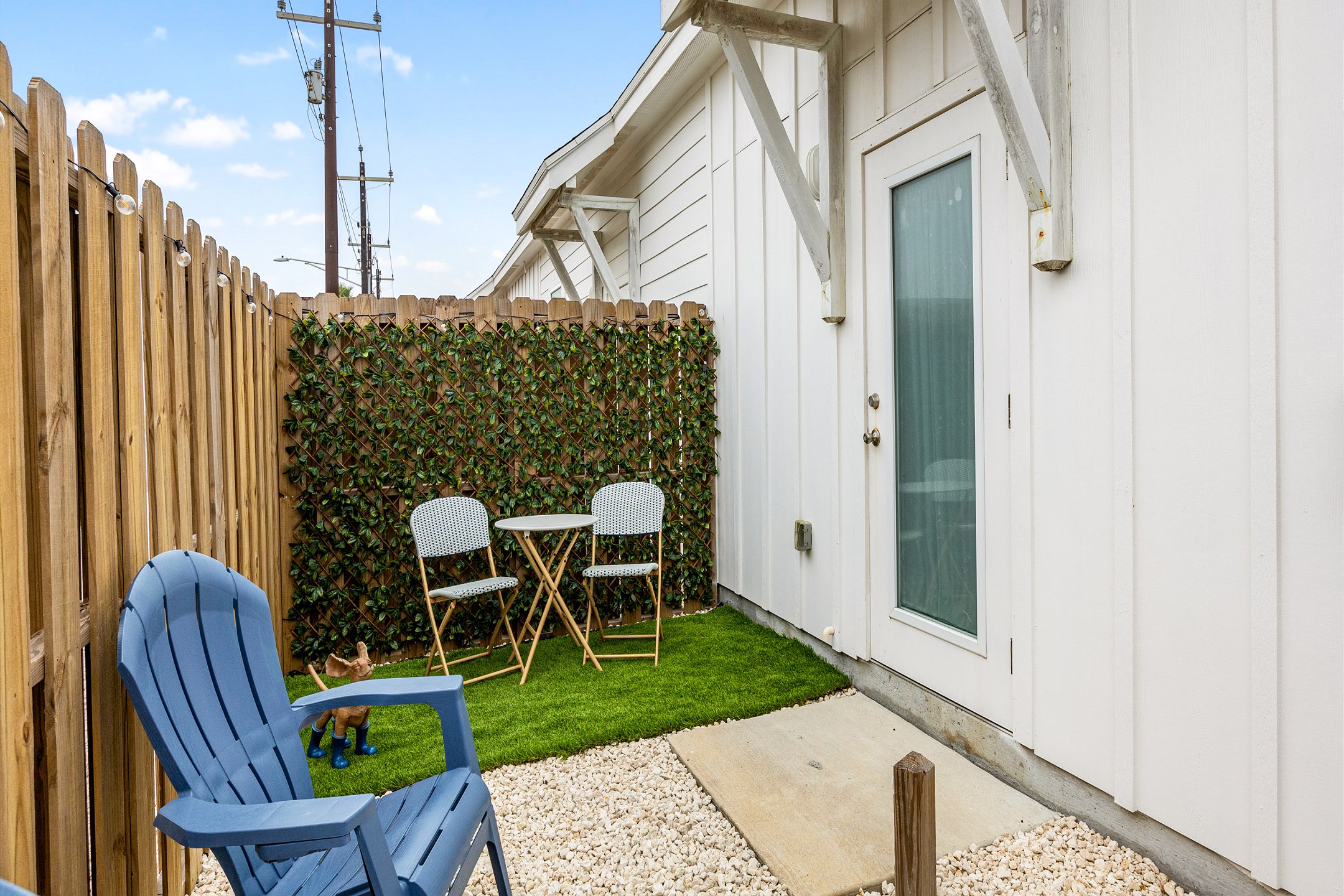 Charming back patio with rock and turf grass, perfect for relaxing or entertaining