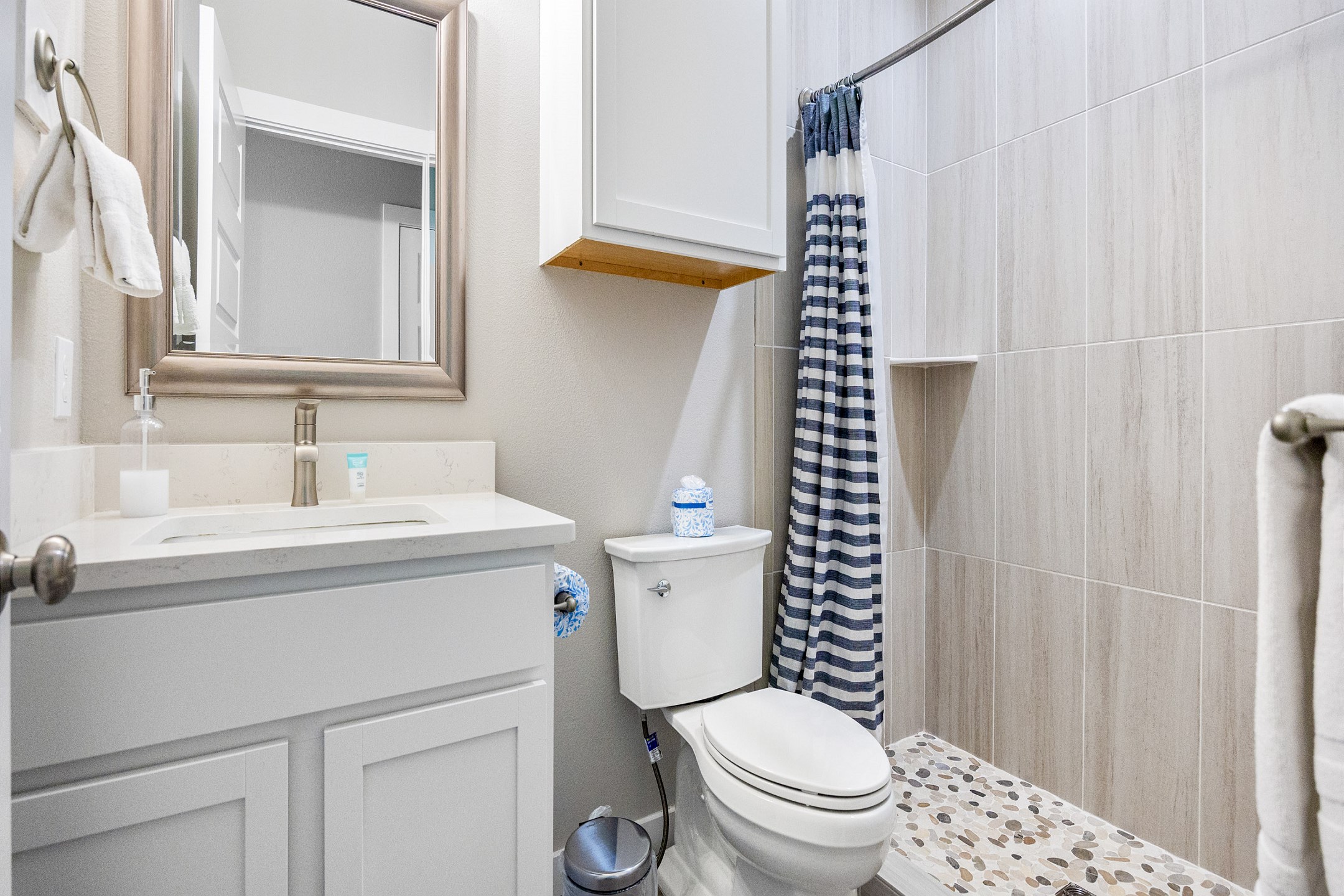 Attached bathroom off the second bedroom with single sink and walk in shower