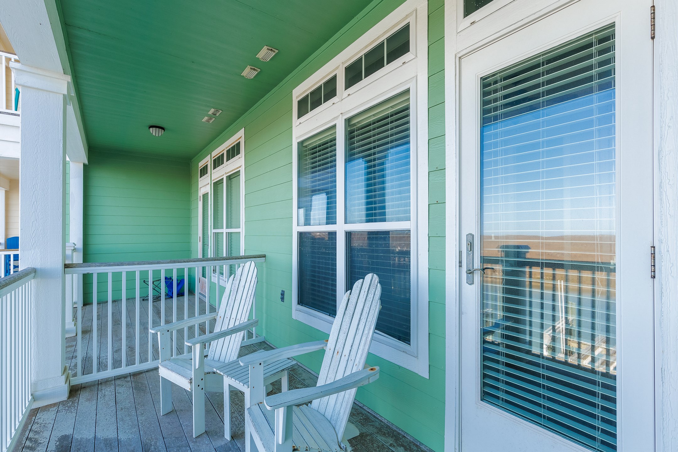 Second floor, private balcony off the master bedroom with chairs and water view 