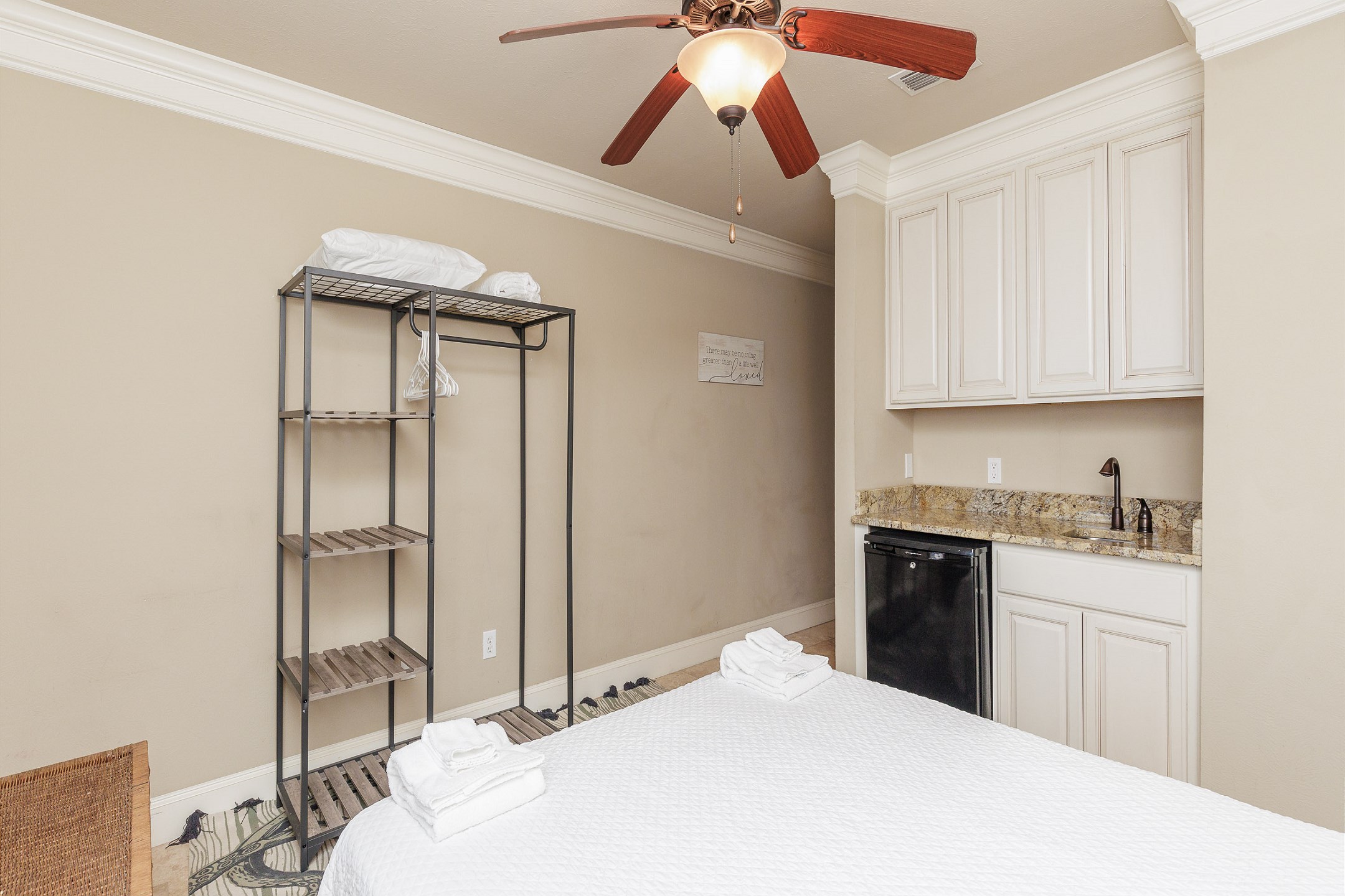 Fourth bedroom on the first floor with queen size bed, mini fridge, and patio access