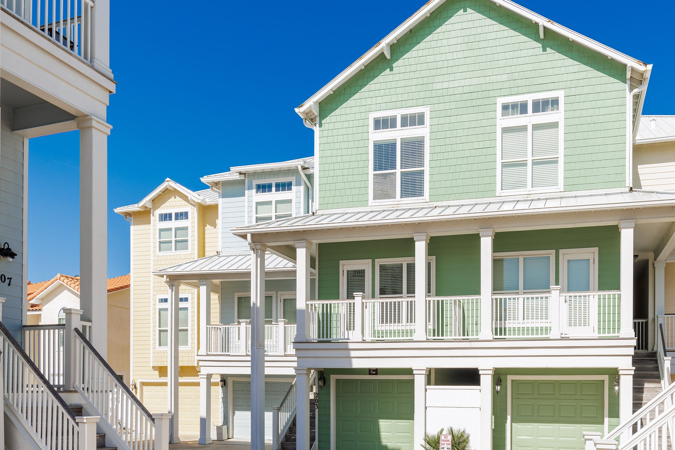Front view of property with stairs to entrance and garage parking