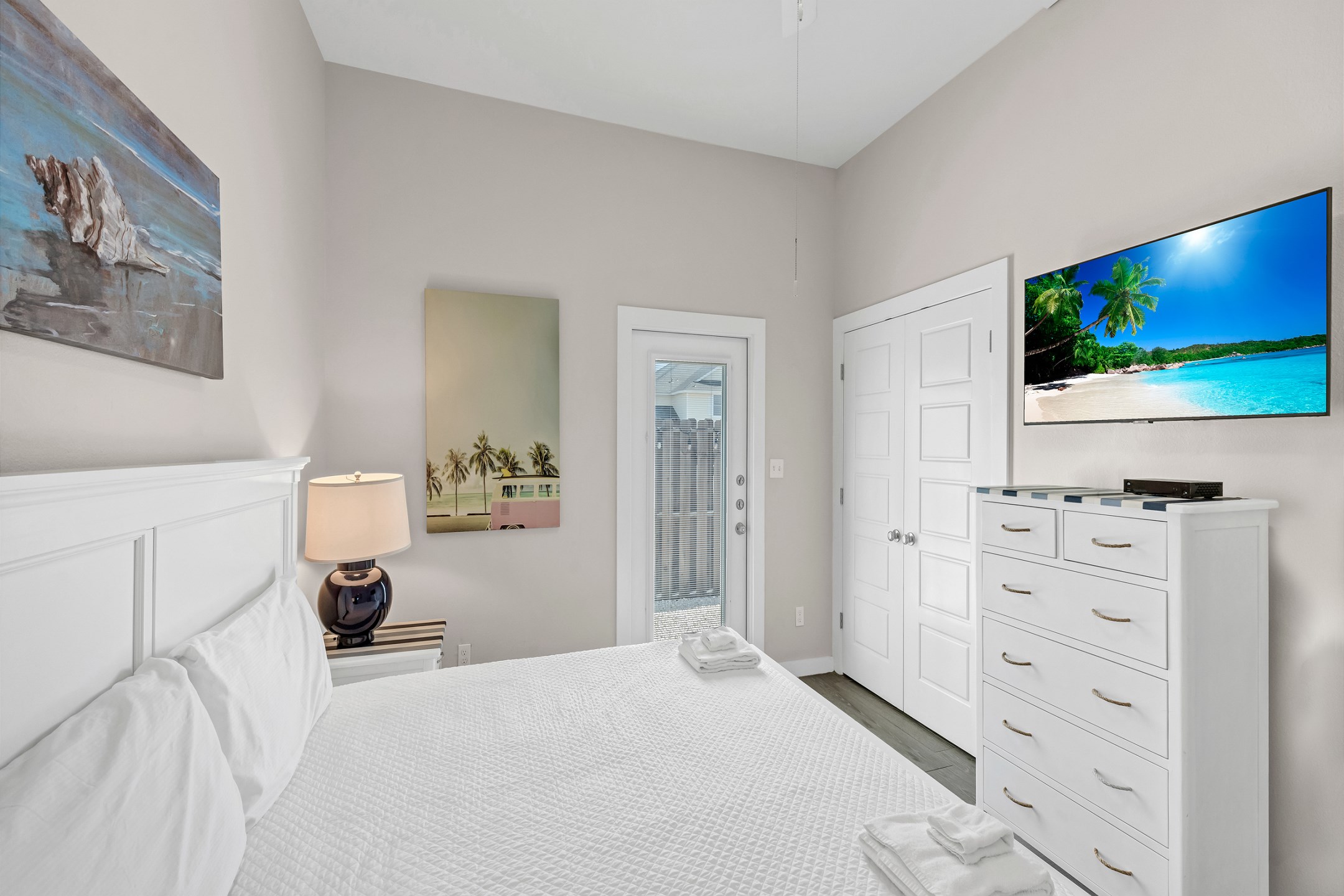 Master bedroom with king size bed, flat screen TV, and back patio access