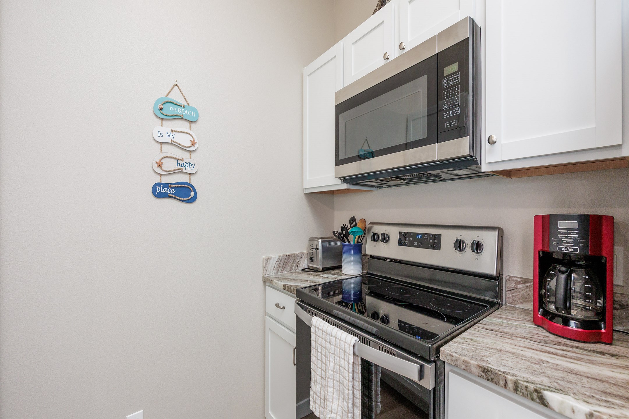 Fully equipped kitchen with coffee maker, toaster, cookware, dinnerware, and other kitchen essentials provided