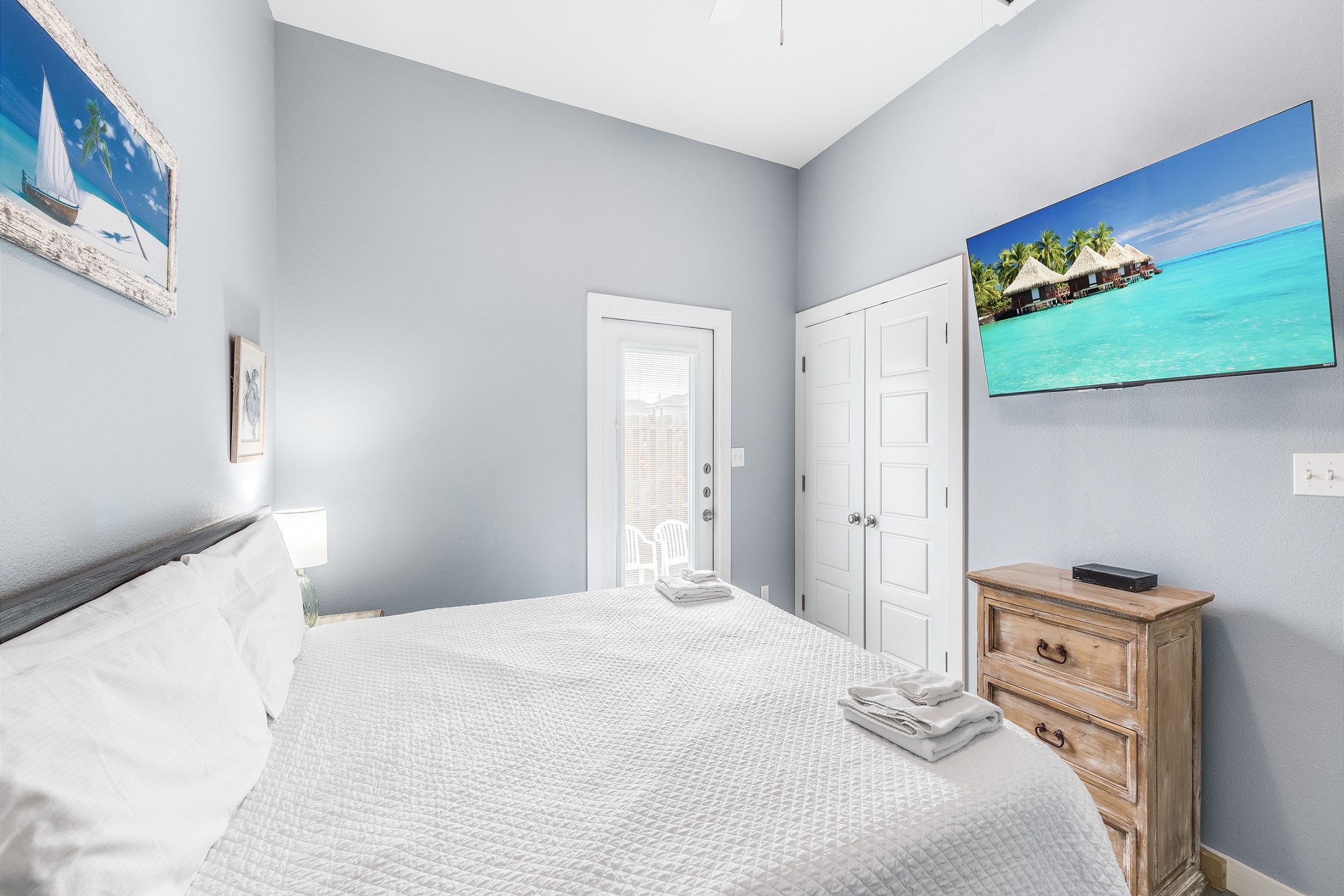 Master bedroom with king size bed, back patio access, and flat screen TV