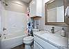 Guest bathroom on the second floor with single sink and tub/shower combo 