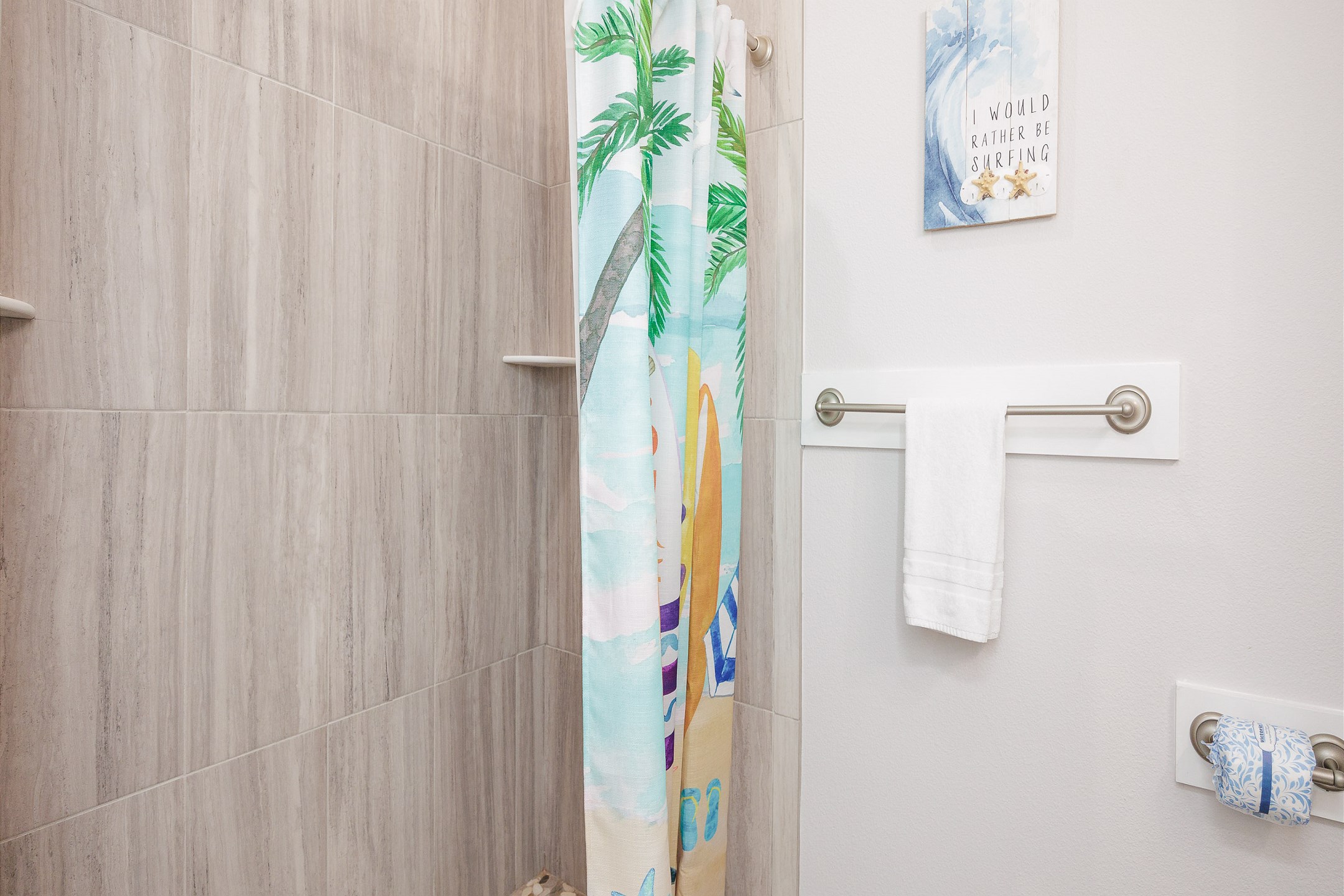 Guest bathroom off the hallway with single sink and walk in shower 