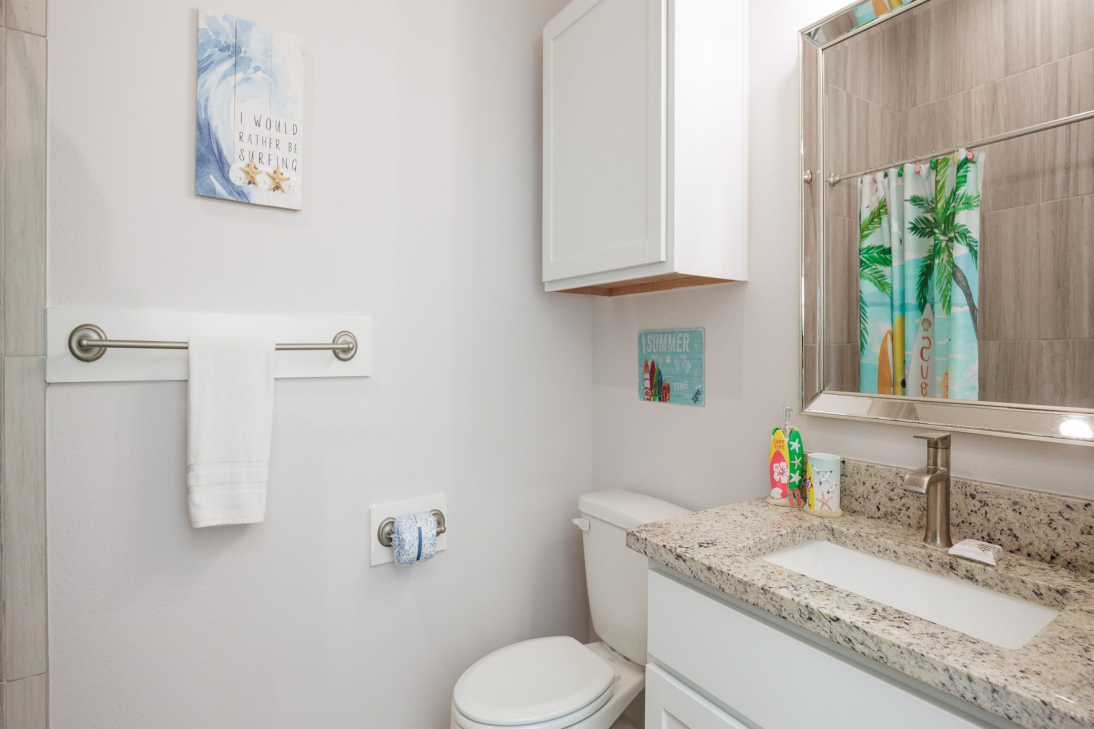 Guest bathroom off the hallway with single sink and walk in shower 