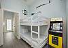 Twin over twin bunk bed in hallway nook with arcade game 