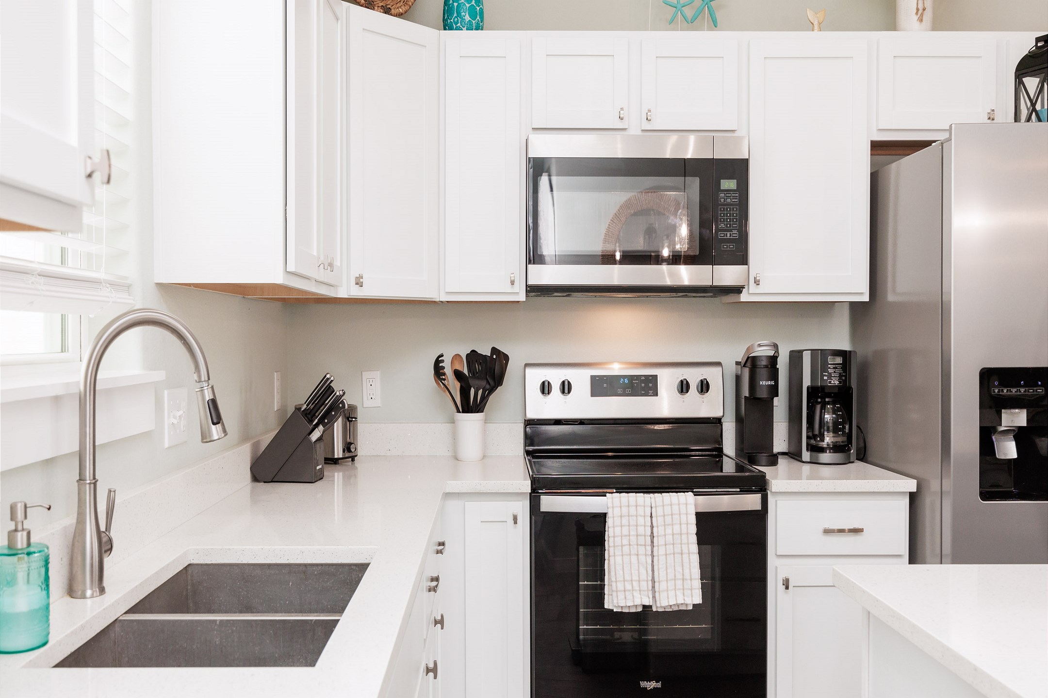 Fully equipped kitchen with coffee maker, toaster, cookware, dinnerware, and other kitchen essentials provided