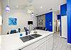 Kitchen area with bright white marble counter top that over looks the living and dining area 