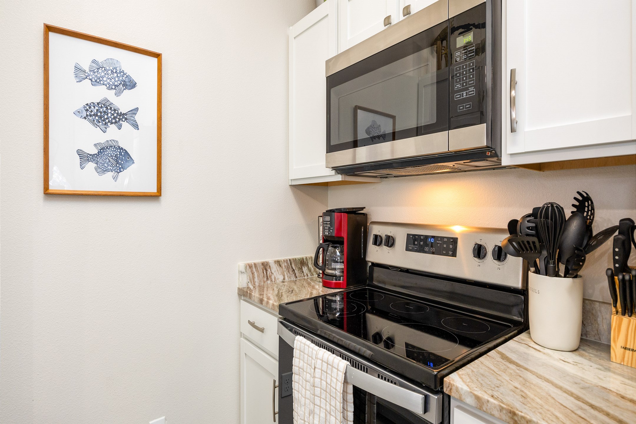 Fully equipped kitchen with coffee maker, toaster, cookware, dinnerware, and other kitchen essentials provided