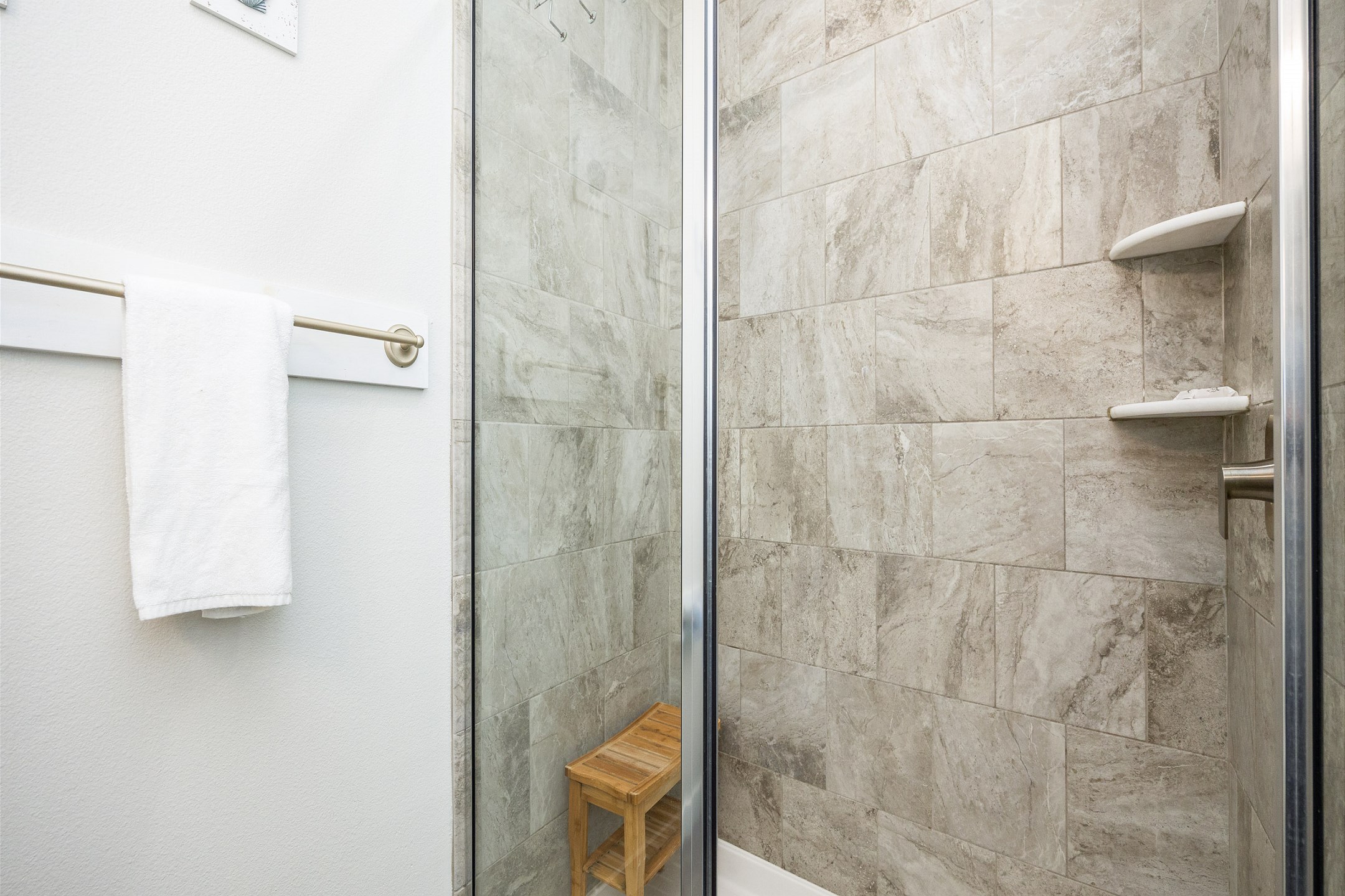 Guest bathroom off hallway with sink, toilet, and walk-in shower 