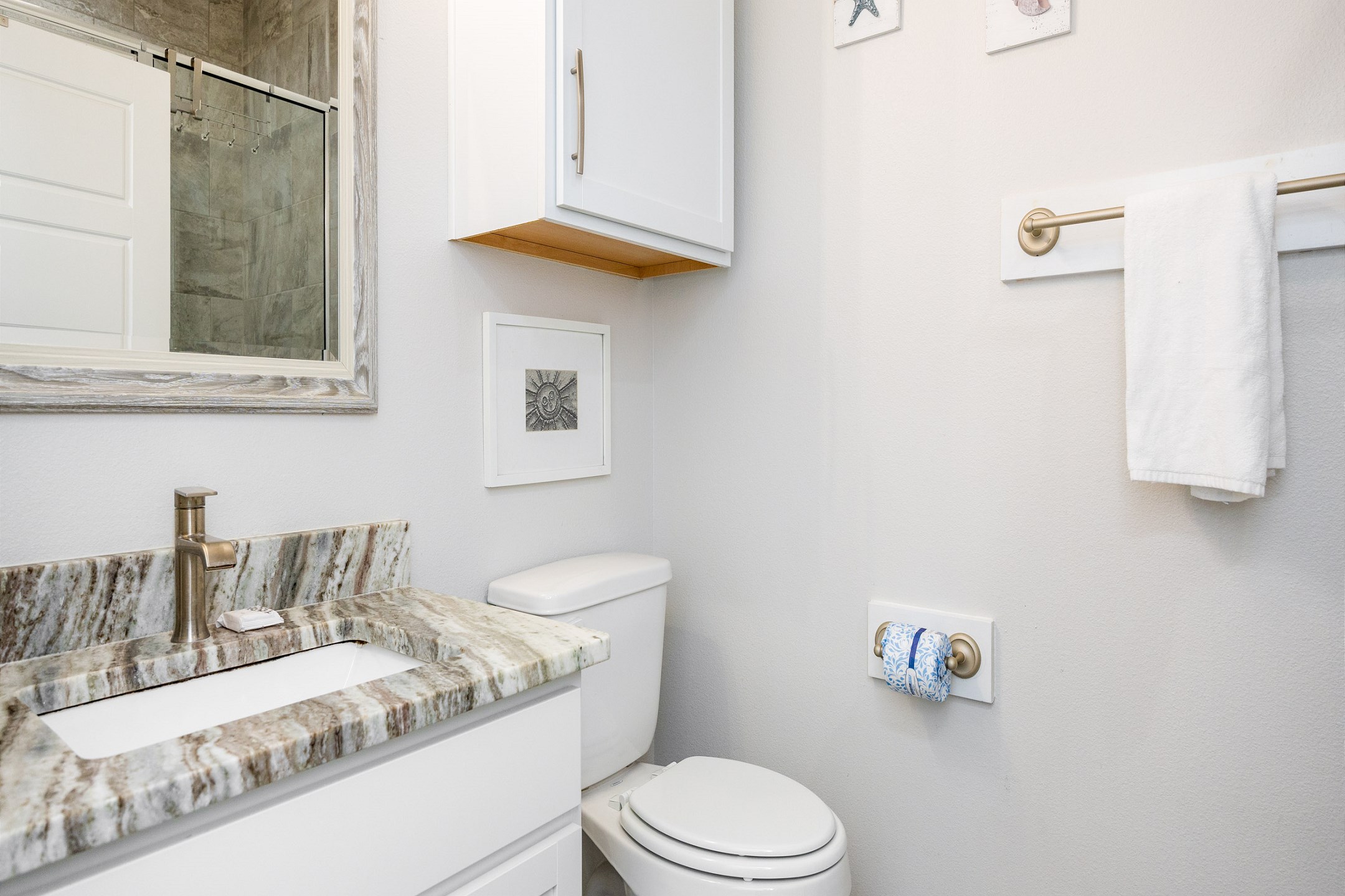 Guest bathroom off hallway with sink, toilet, and walk-in shower 