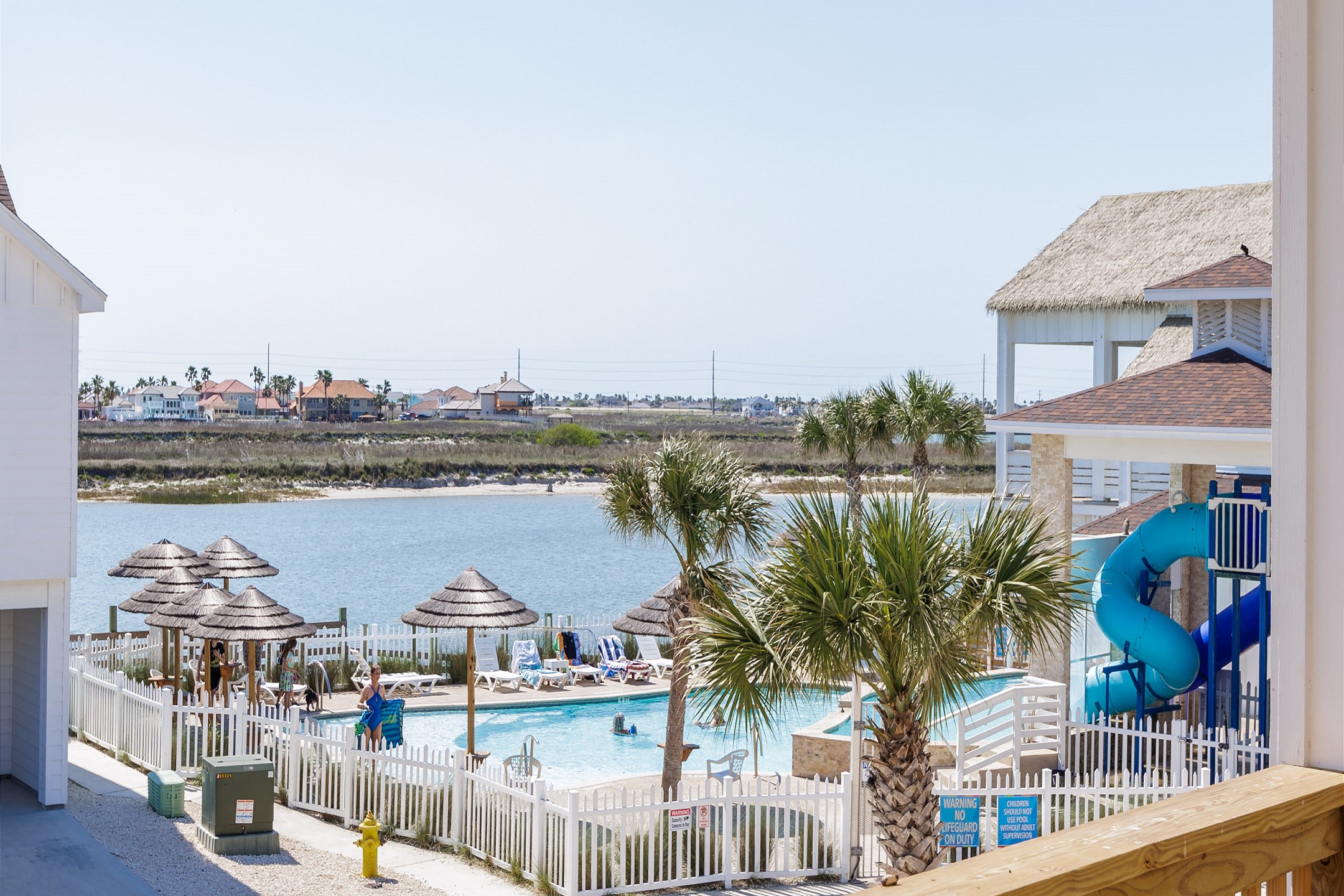 Shared balcony off the bedrooms with cozy seating that over looks the pool and canal 