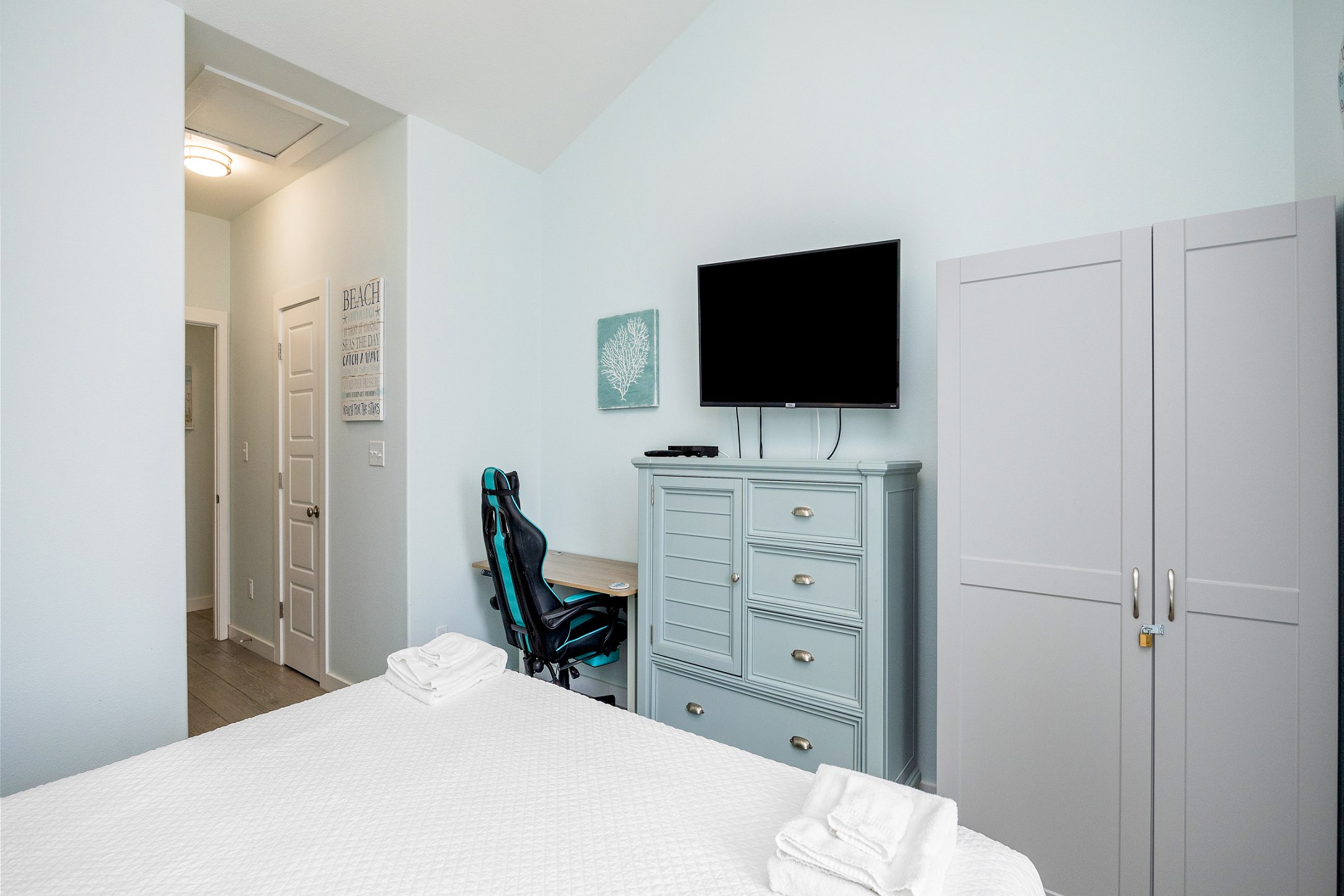 Master bedroom on the second floor with king size bed, private balcony, ensuite bathroom, desk, and flat screen TV 