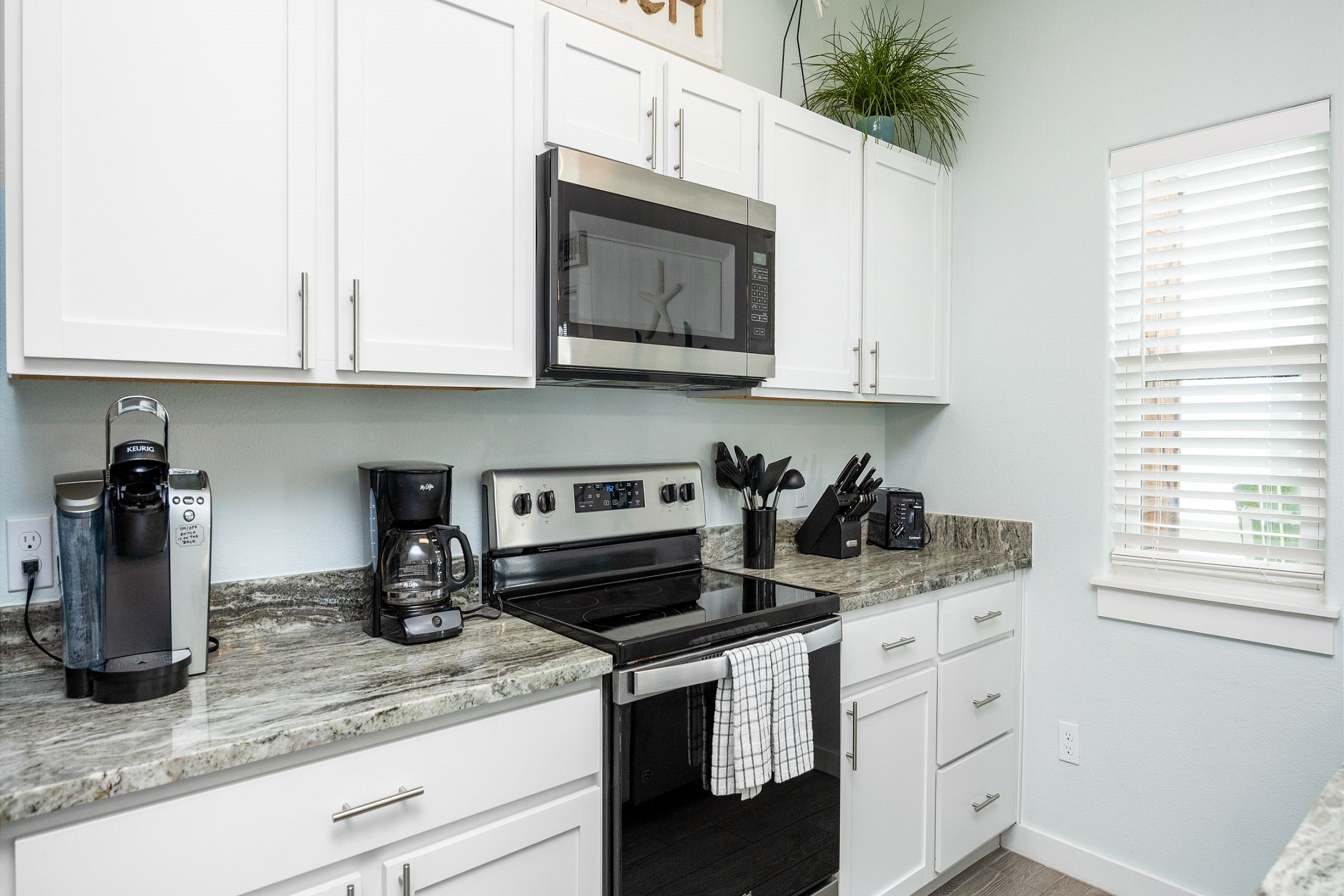 Sleek modern kitchen boasting granite countertops and ample space for preparing a full meal