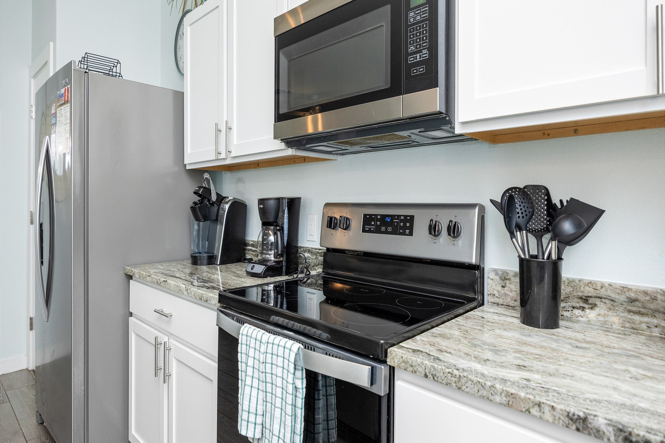 Fully equipped kitchen with coffee maker, toaster, cookware, dinnerware, and other kitchen essentials provided