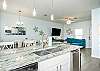 Fully stocked kitchen with barstools and coffee maker 