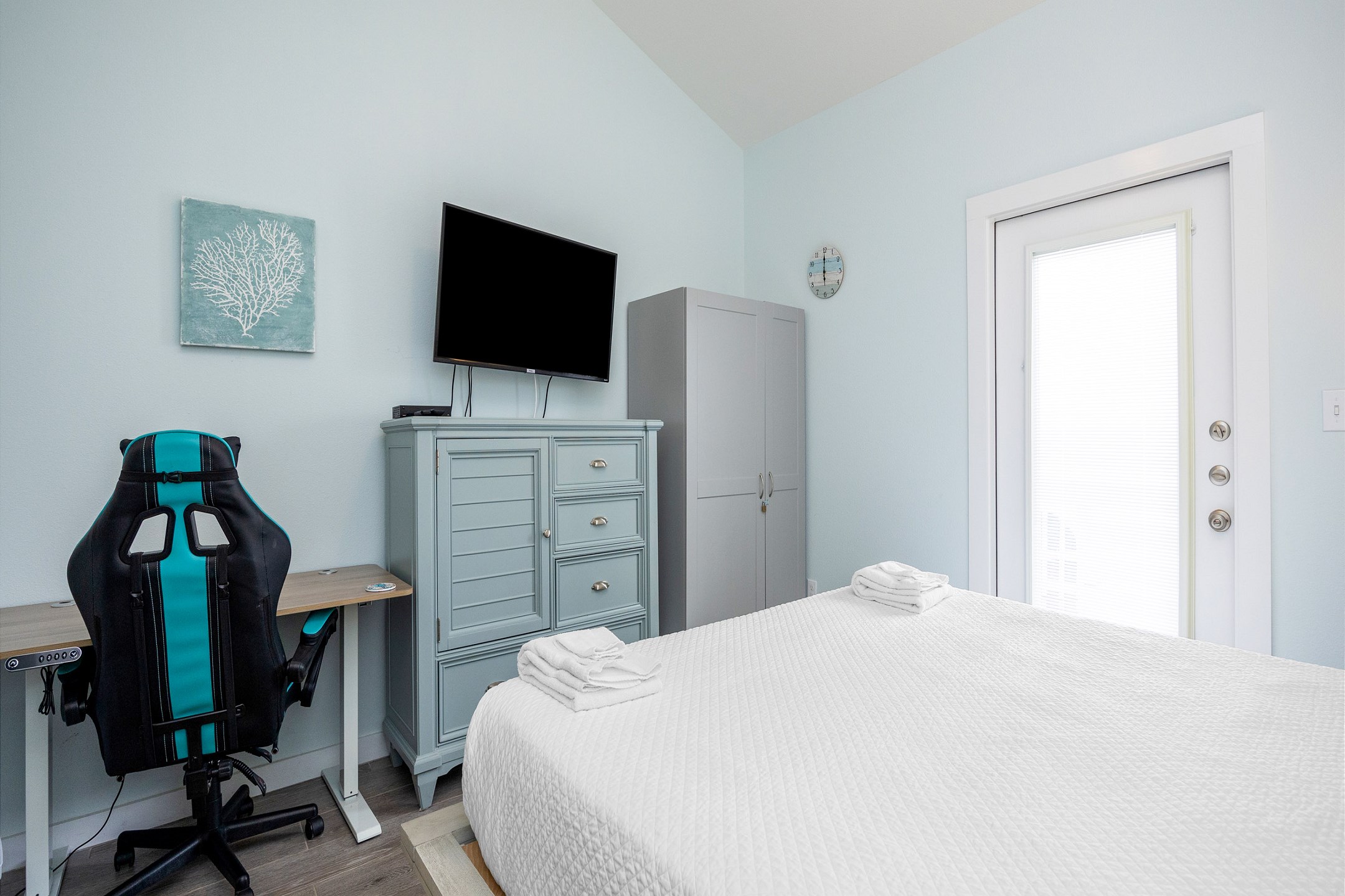 Master bedroom on the second floor with king size bed, private balcony, ensuite bathroom, desk, and flat screen TV 