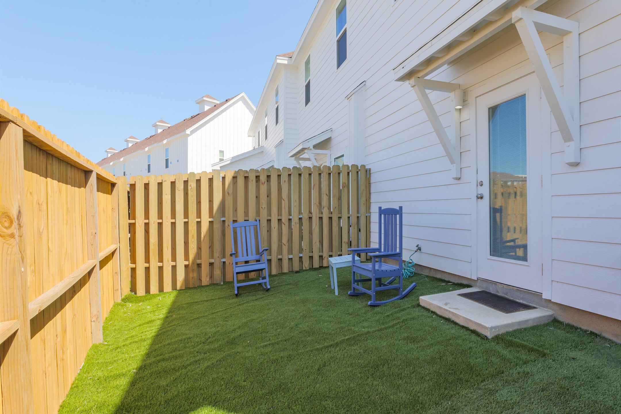 Charming back patio featuring turf grass, perfect for relaxing or entertaining