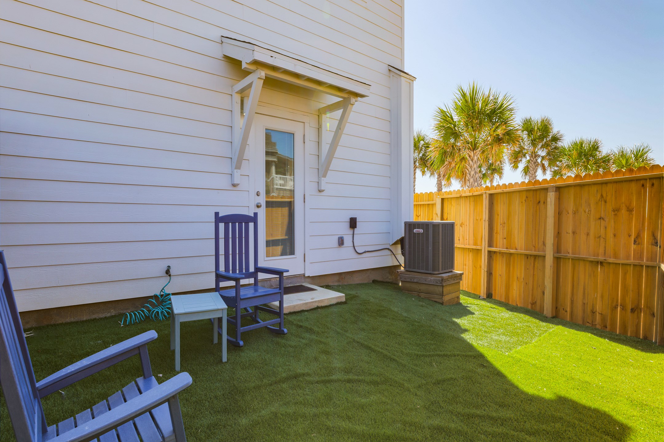 Charming back patio featuring turf grass, perfect for relaxing or entertaining