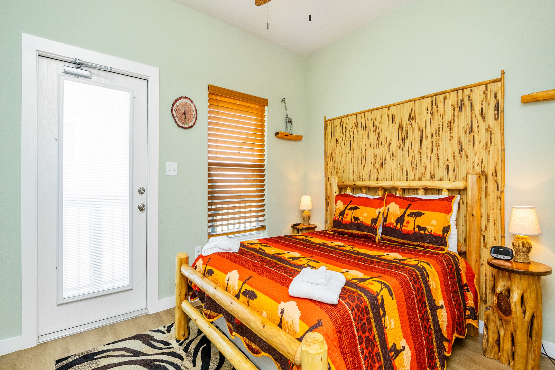 Safari-inspired second bedroom on the second floor with a queen size bed, access to the balcony, and flat screen TV 