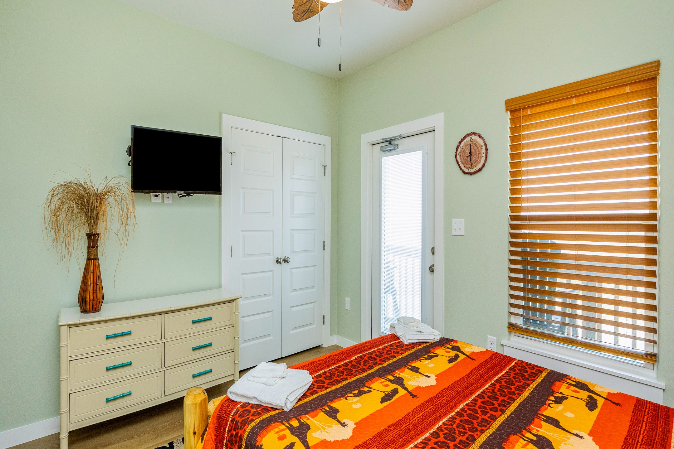Safari-inspired second bedroom on the second floor with a queen size bed, access to the balcony, and flat screen TV 