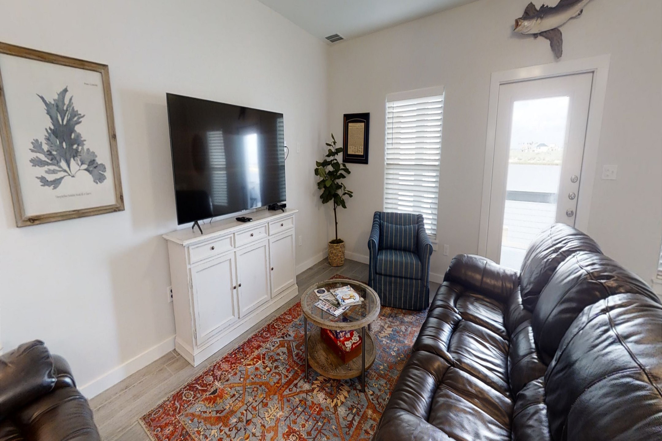 Unwind in the cozy living area featuring comfortable seating, a flat-screen TV and direct access to the first-floor back patio - perfect for relaxation and outdoor enjoyment