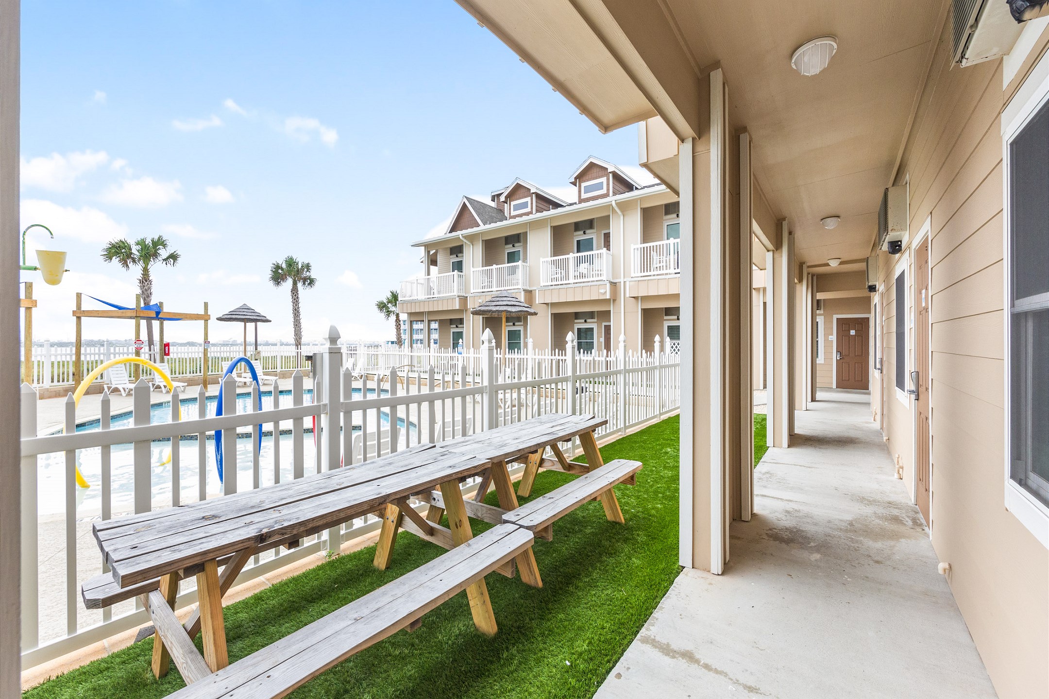 Picnic tables with a pool side view 