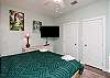 Master bedroom with king size bed, 55-inch flat screen TV, and private bathroom