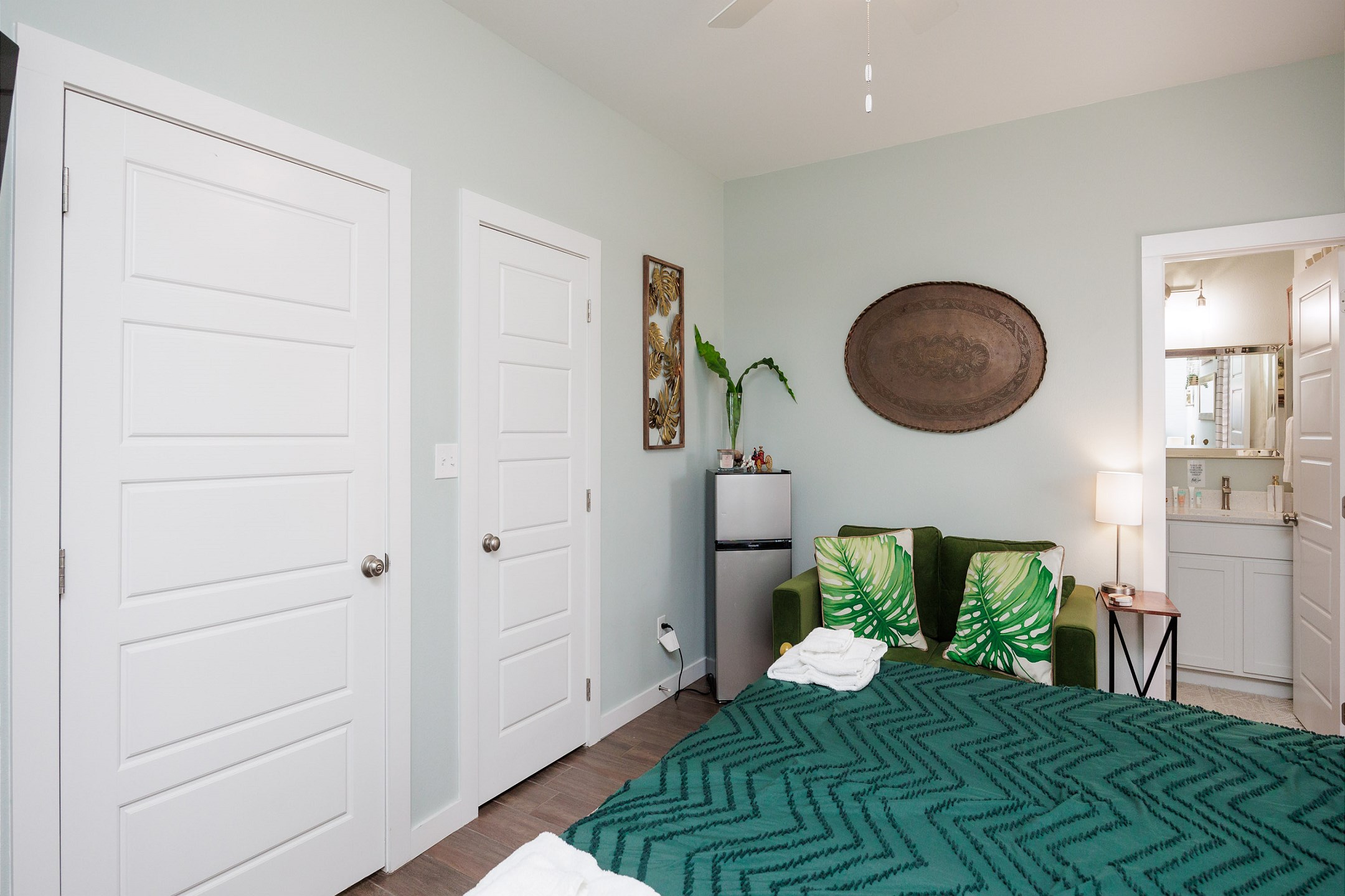 Master bedroom on the first floor with king size bed, private bathroom, access to private patio, and 55-inch flat screen TV